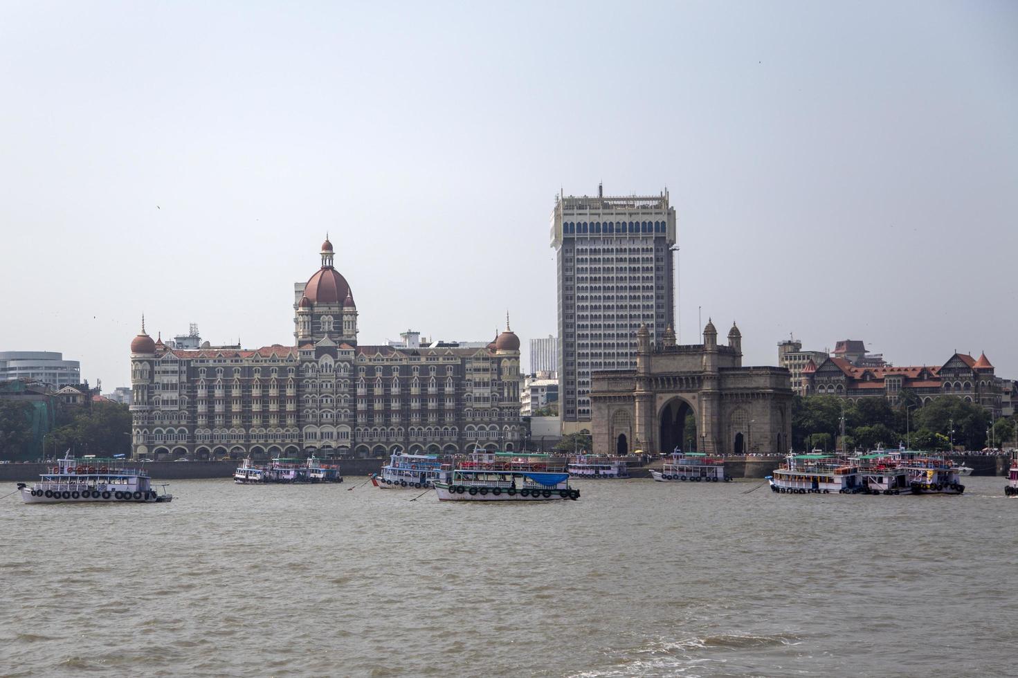 MUMBAI, INDIA, OCTOBER 11, 2015 - Boats in front of the Taj Mahal Palace Hotel. This 5 star hotel is considered the flagship property of the group and contains 560 rooms and 44 suites. photo