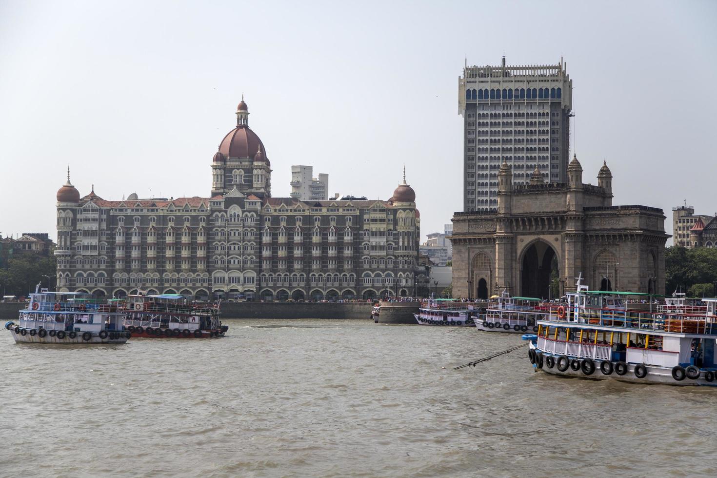 MUMBAI, INDIA, OCTOBER 11, 2015 - Boats in front of the Taj Mahal Palace Hotel. This 5 star hotel is considered the flagship property of the group and contains 560 rooms and 44 suites. photo