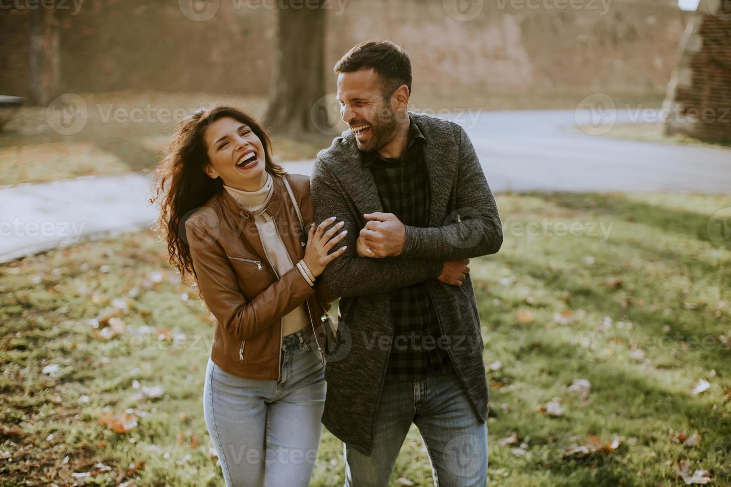 Happy young couple walking in autumn park photo