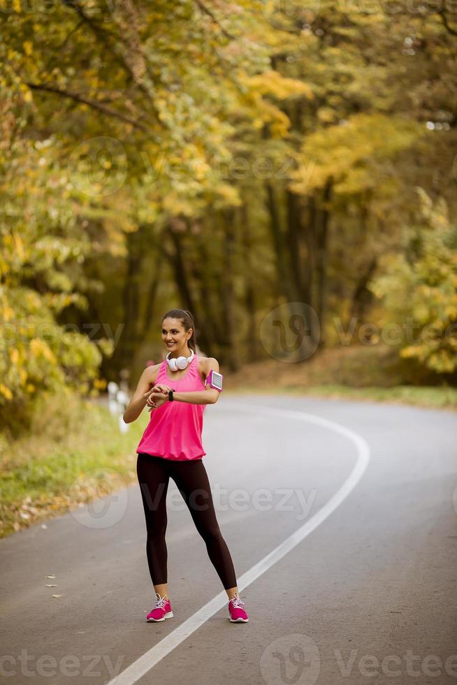 Young woman have a break during training in the autumn forest photo