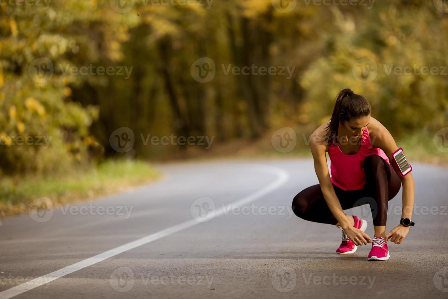 Young woman have a break during training in the autumn forest photo