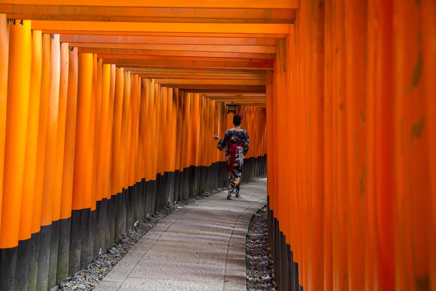 KYOTO, JAPAN, OCTOBER 8, 2016 - Unidentified woman at walkway in Fushimi Inari shrine in Kyoto, Japan. This popular shrine have 32,000 sub-shrines  throughout Japan photo