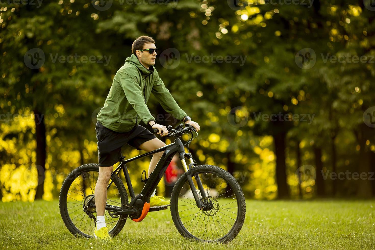 Young man riding ebike in the park photo