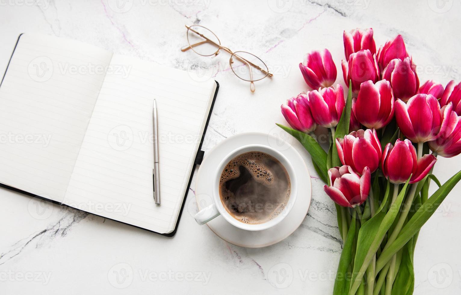 cuaderno, taza de café y tulipanes rosas foto