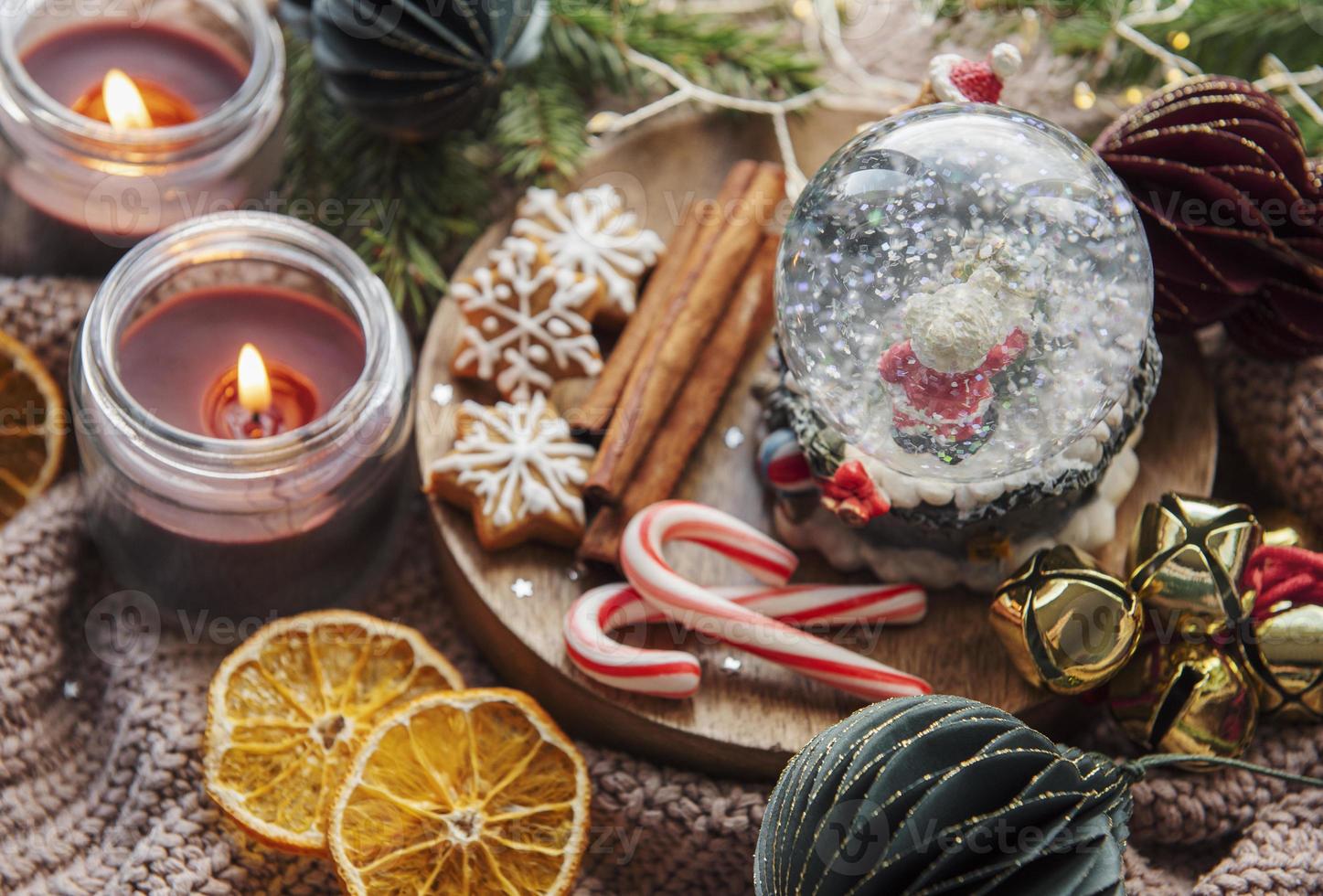 A snow globe and christmas candles with branches of fir. photo