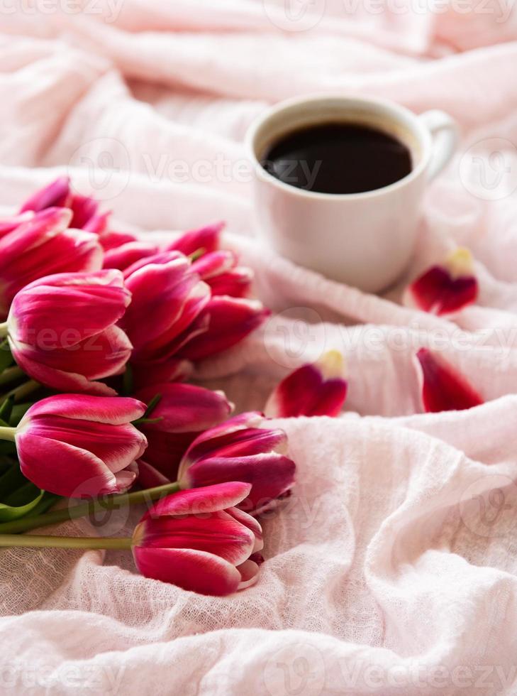 Cup of coffee and pink tulips photo