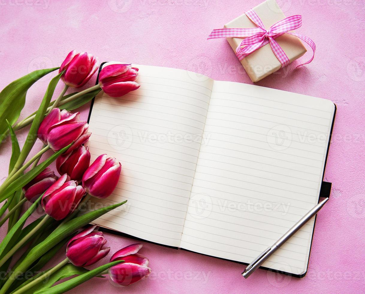 cuaderno, caja de regalo y tulipanes rosas foto