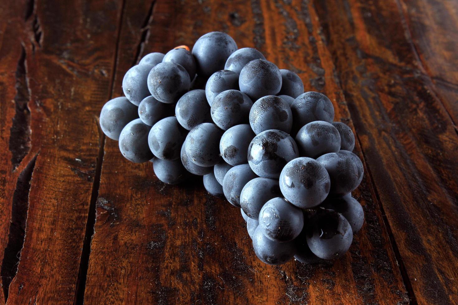 bunches of fresh grapes on rustic wooden table photo