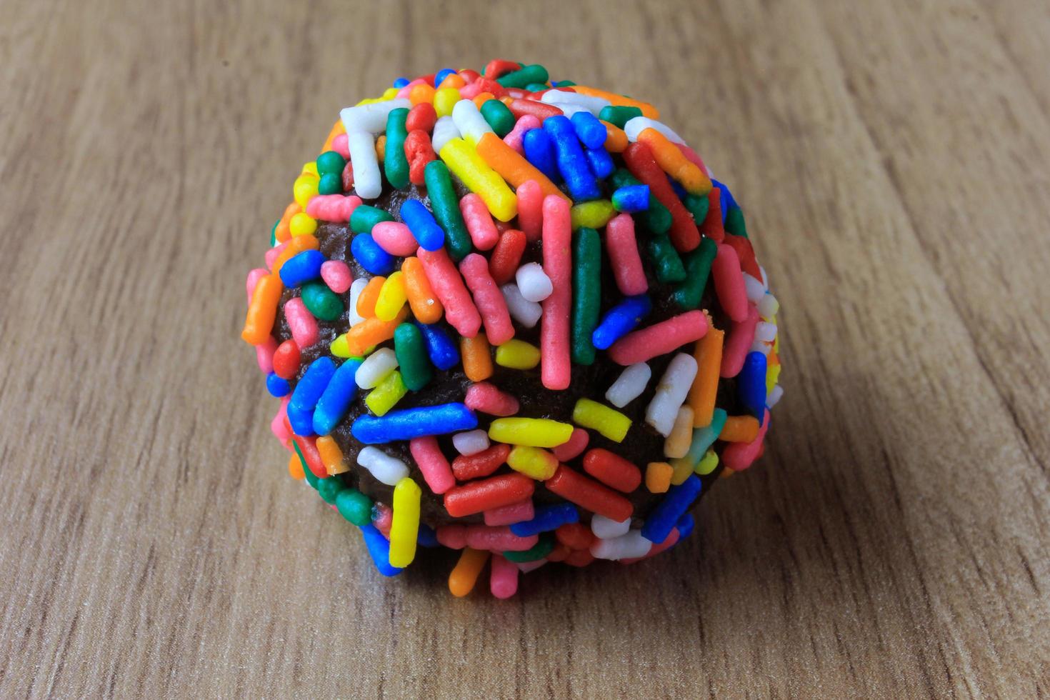 brigadeiro, brigadier, sweet chocolate typical of Brazilian cuisine covered with particles, in a wooden background. photo