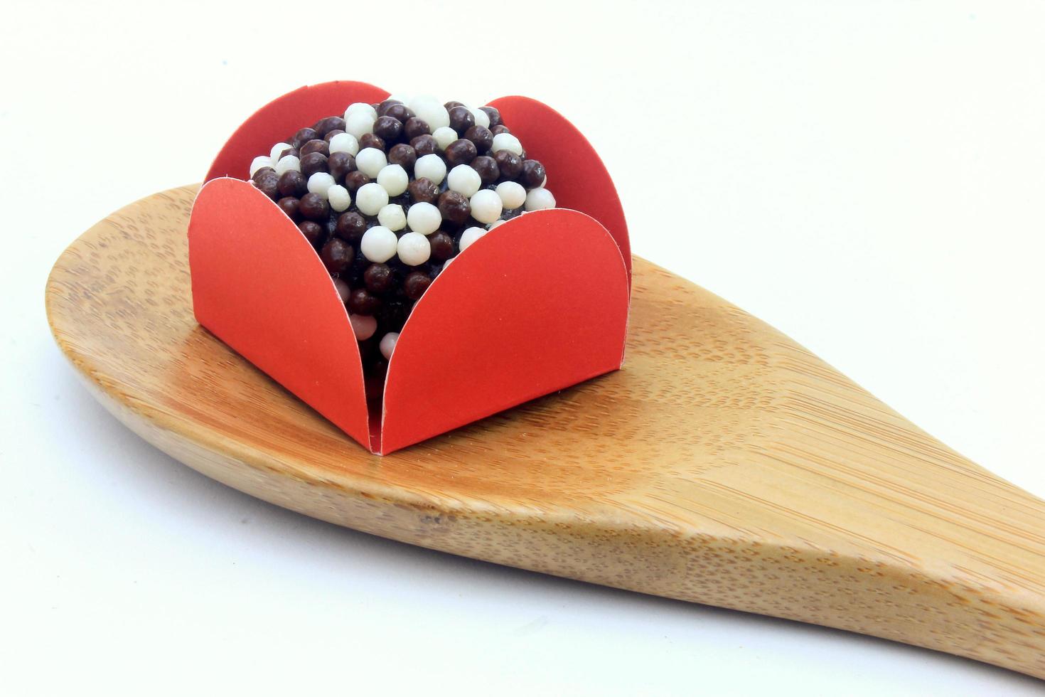 brigadeiro, brigadier, sweet chocolate typical of Brazilian cuisine covered with particles, in a wooden background. photo