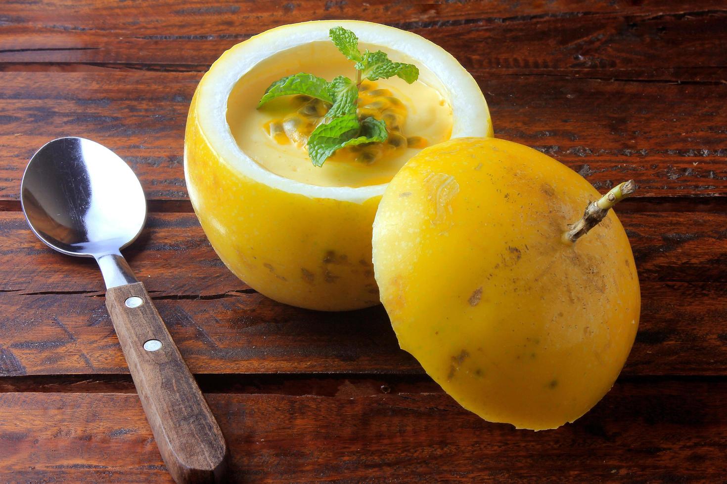 dessert Passion fruit mousse in the peel of fruit on rustic wooden table photo