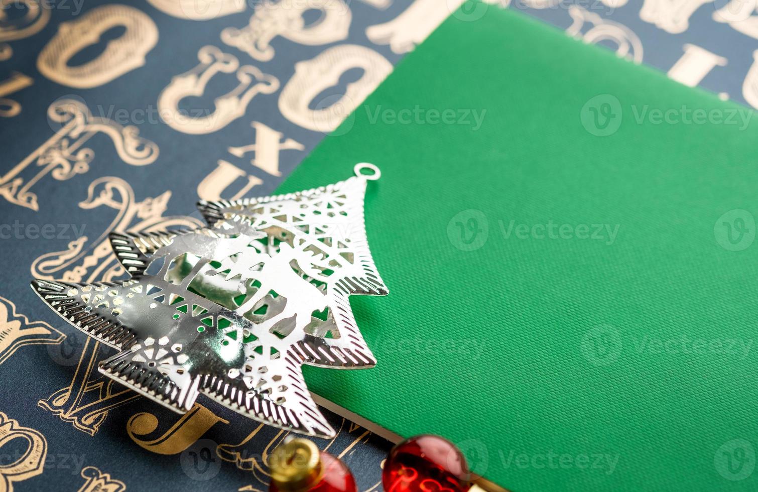 Decoración del árbol de navidad con cuaderno verde sobre patrón de tipo antiguo foto