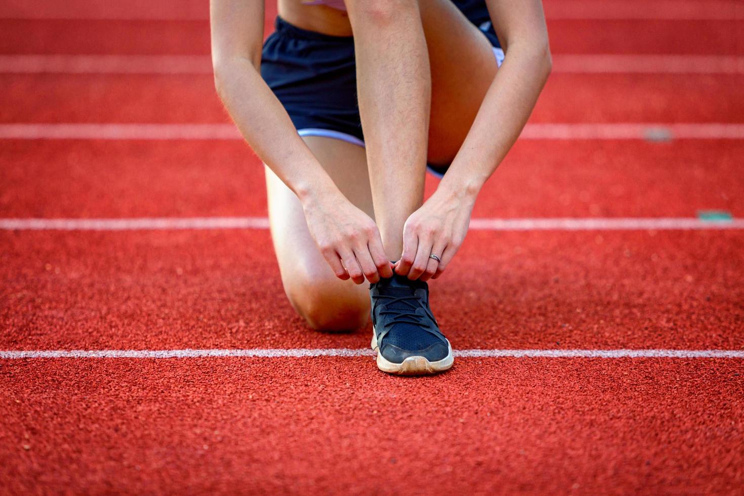 Women tying a rope are preparing to run in the running tracker. The runner women concept for healthy. photo