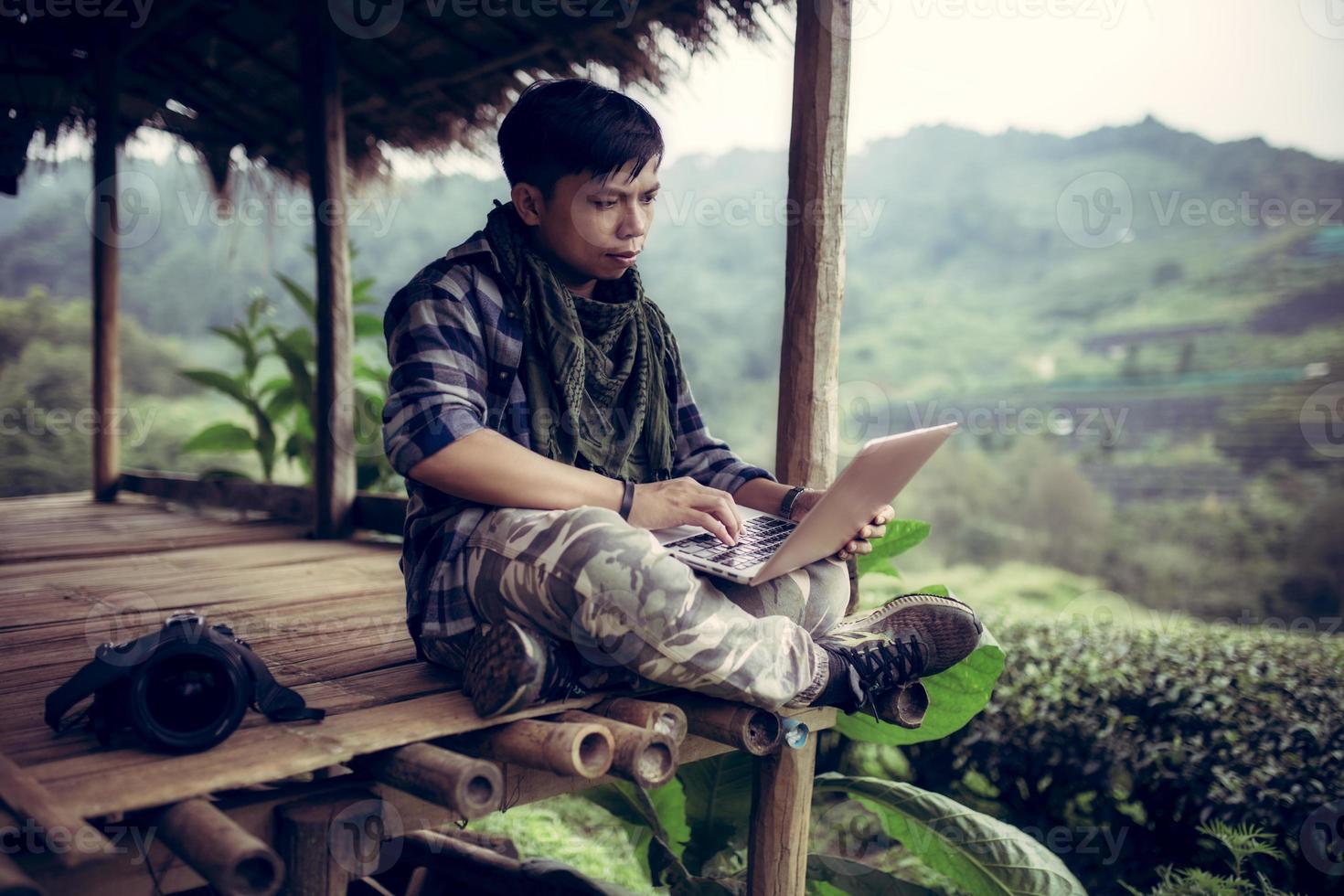 Asian young freelance man use laptop working about editor or blogger travel in Doi Ang Khang 2000 green tea farm Chiang Mai Thailand. photo