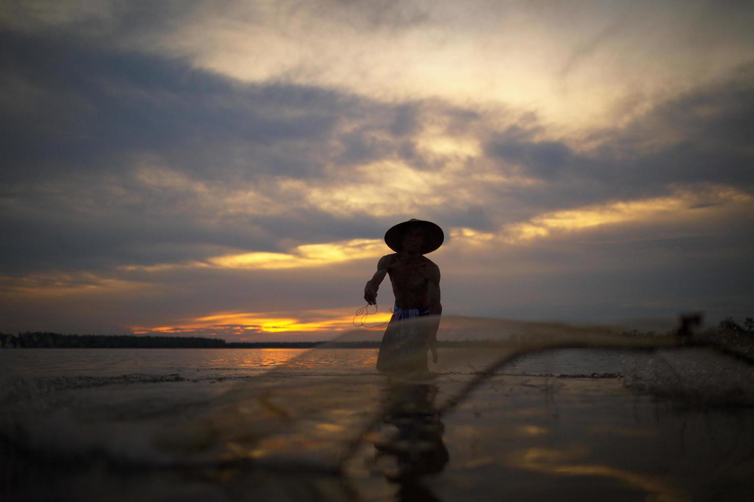 Lifestyles of fishermen are netting to catch fish in the lake on sunset photo