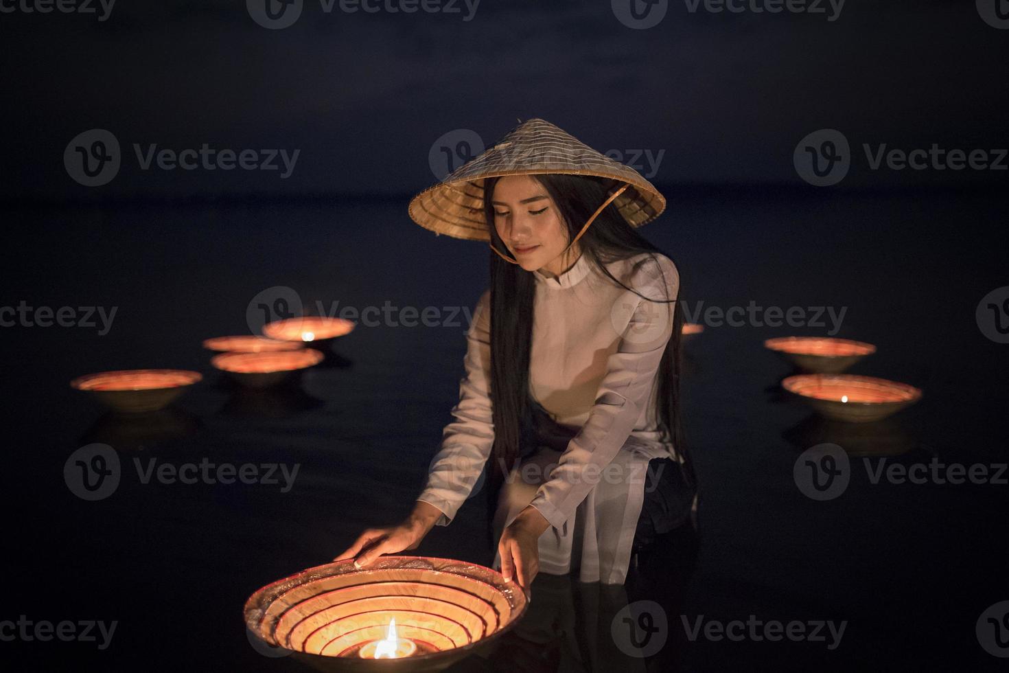 Vietnamese Women wearing  Ao Dai Vietnam Traditional dress on the lake with lamp photo
