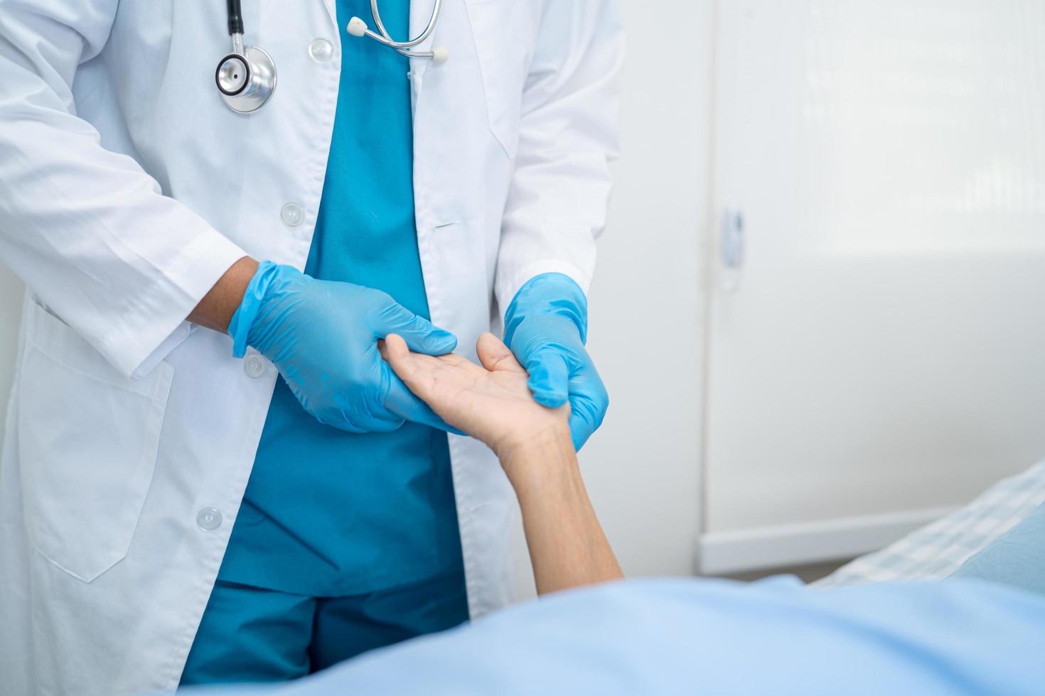 El médico ayuda a la paciente asiática mayor o anciana en el hospital para proteger la infección de seguridad y matar el coronavirus covid-19. foto