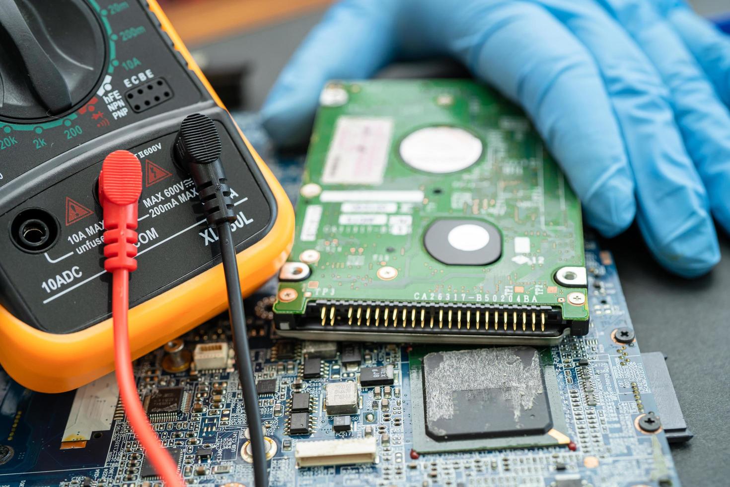 technician repairing inside of hard disk by soldering iron. Integrated Circuit. the concept of data, hardware, technician and technology. photo