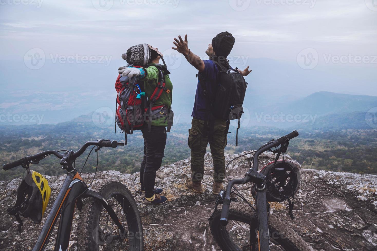 Asian lover women and men Travel Nature. Travel relax ride a bike Wilderness in the wild. Standing on a rocky cliff. Thailand photo