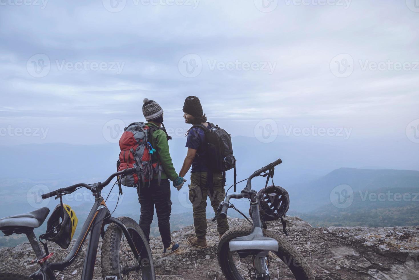 Asian lover women and men Travel Nature. Travel relax ride a bike Wilderness in the wild. Standing on a rocky cliff. Thailand photo