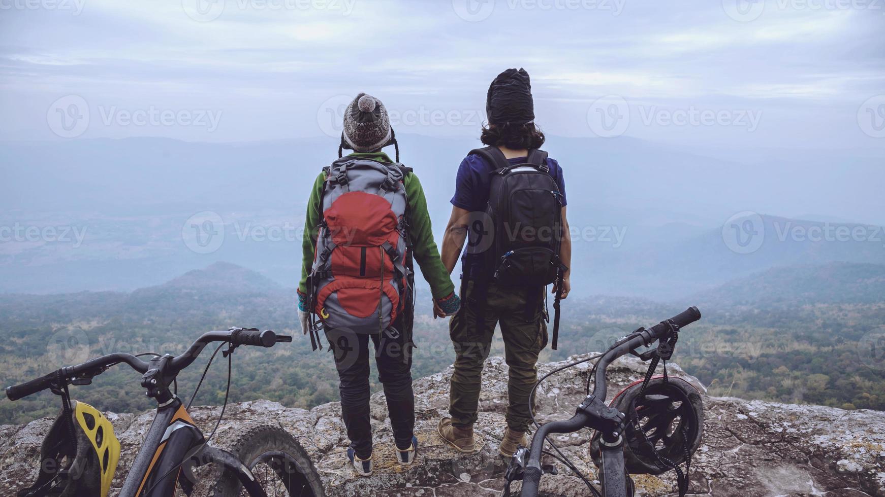 Asian lover women and men Travel Nature. Travel relax ride a bike Wilderness in the wild. Standing on a rocky cliff. Thailand photo