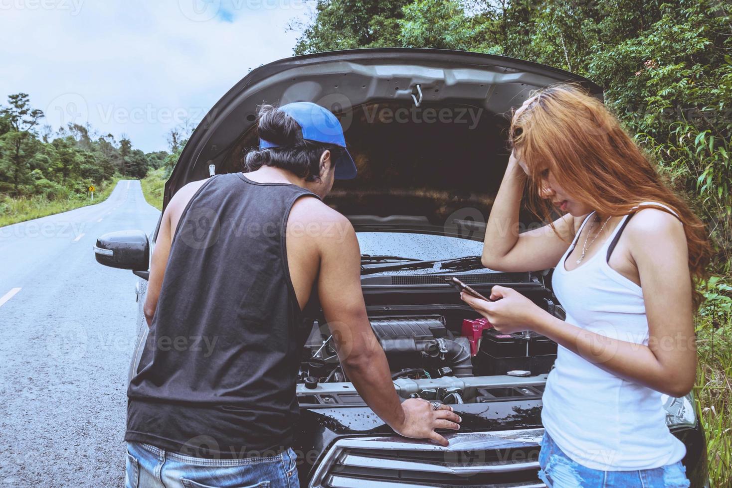 Los amantes de las mujeres y los hombres asiáticos viajan relajarse en las vacaciones. coche averiado en la calle. tailandia foto