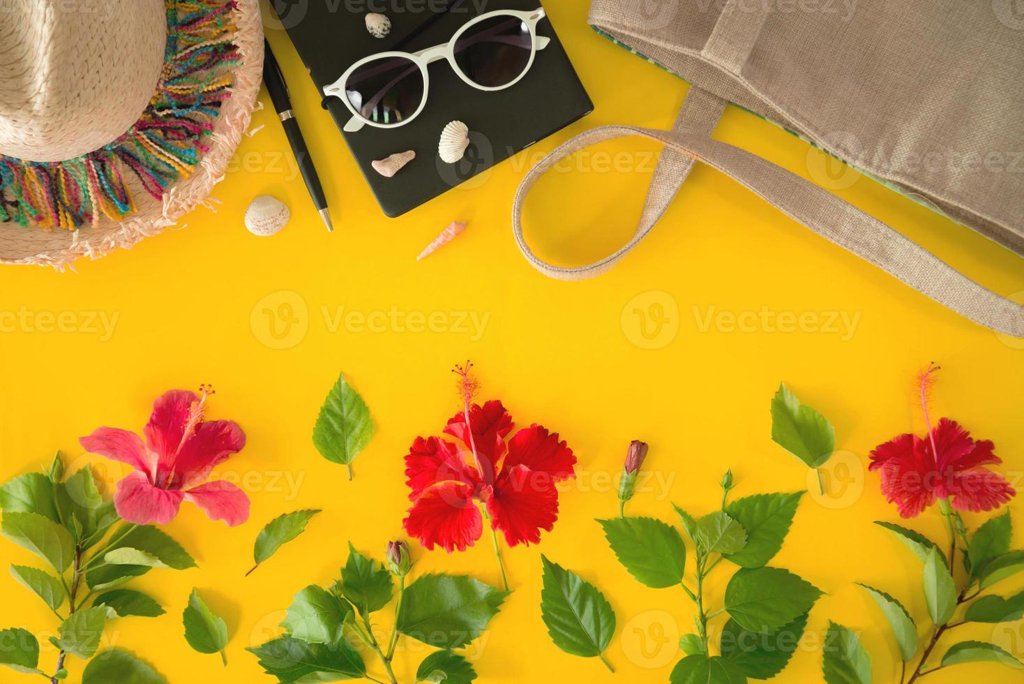 Beach accessories For the traveler on the yellow background - sunglasses, Straw hat, backpack, Shell, and hibiscus flowers. Beach tourism concept. summer photo