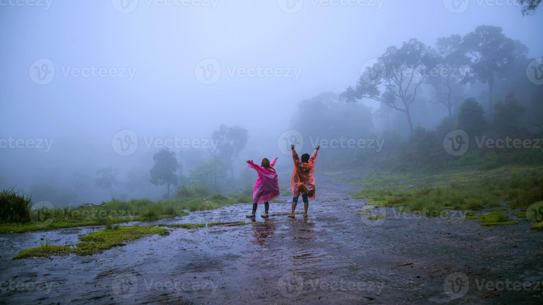 couples tourist with rain coat walking travel adventure nature in the rain forest. travel nature, Travel relax, Travel Thailand, rainy season, Happy, romantic. photo