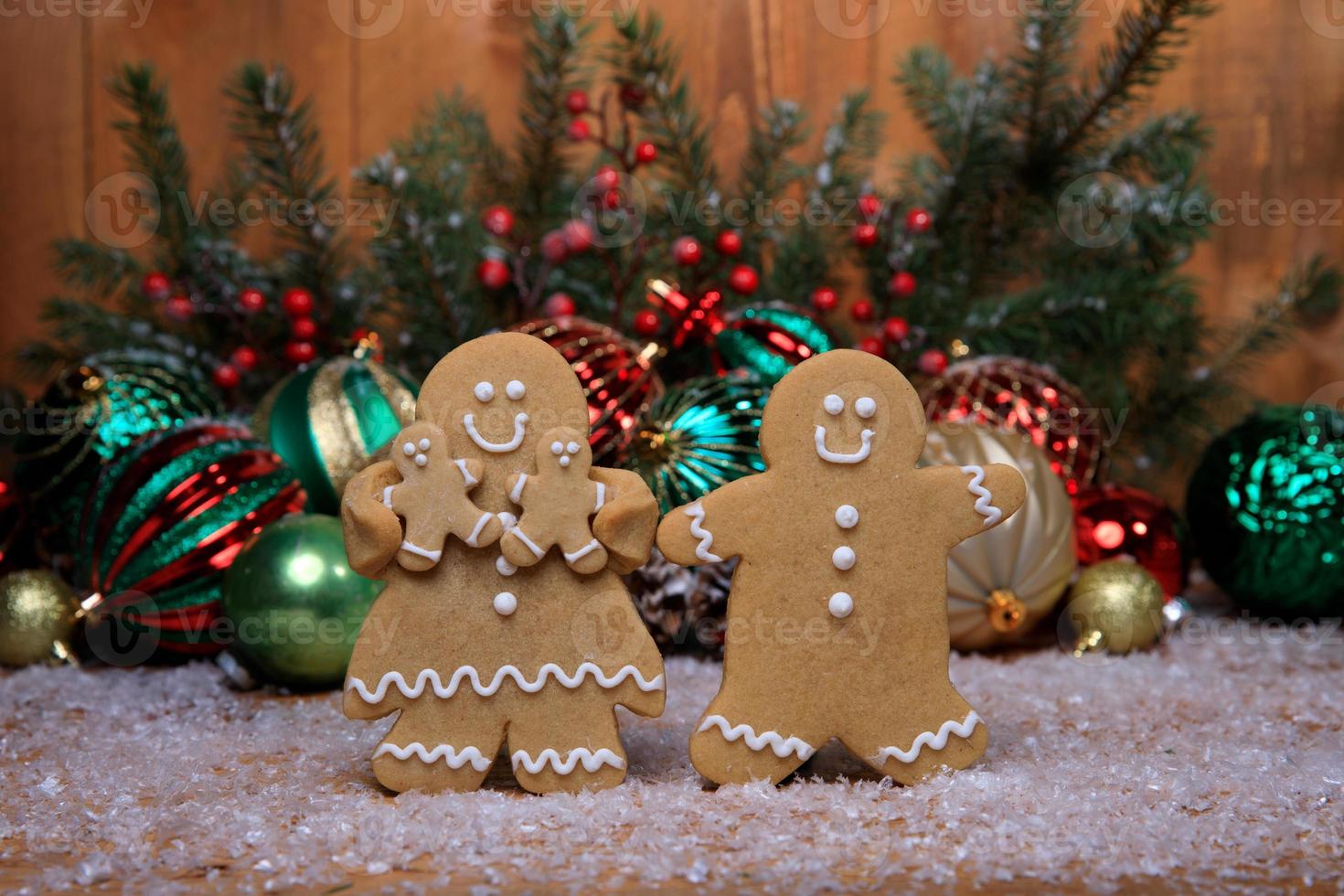 Familia de pan de jengibre con 2 niños en vacaciones de fondo navideño foto