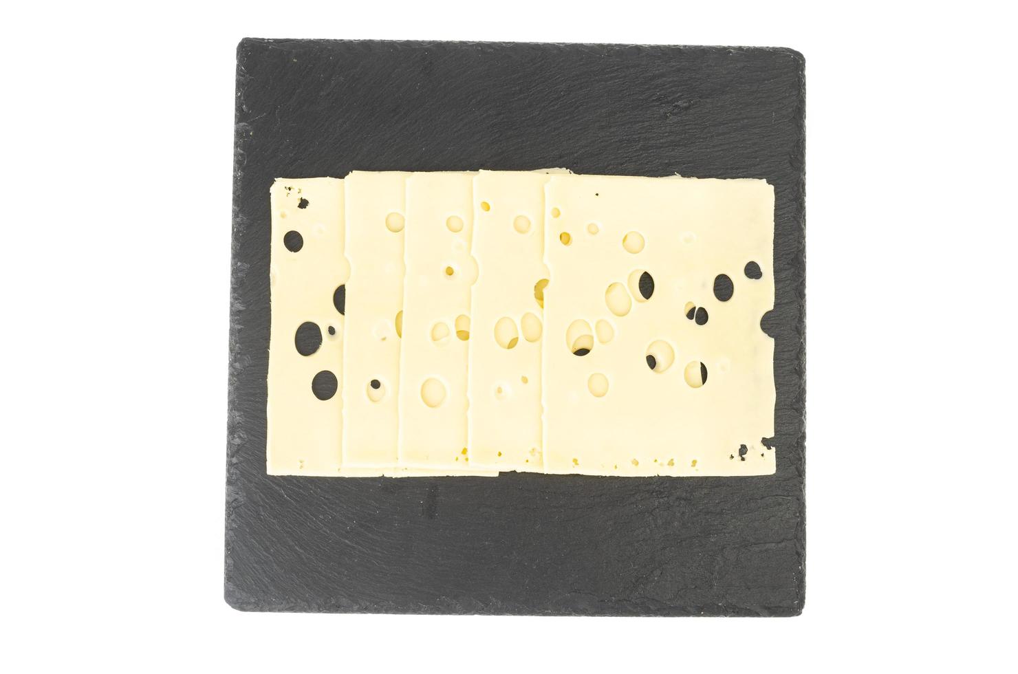 Sliced Maasdam cheese on black plate. Studio Photo