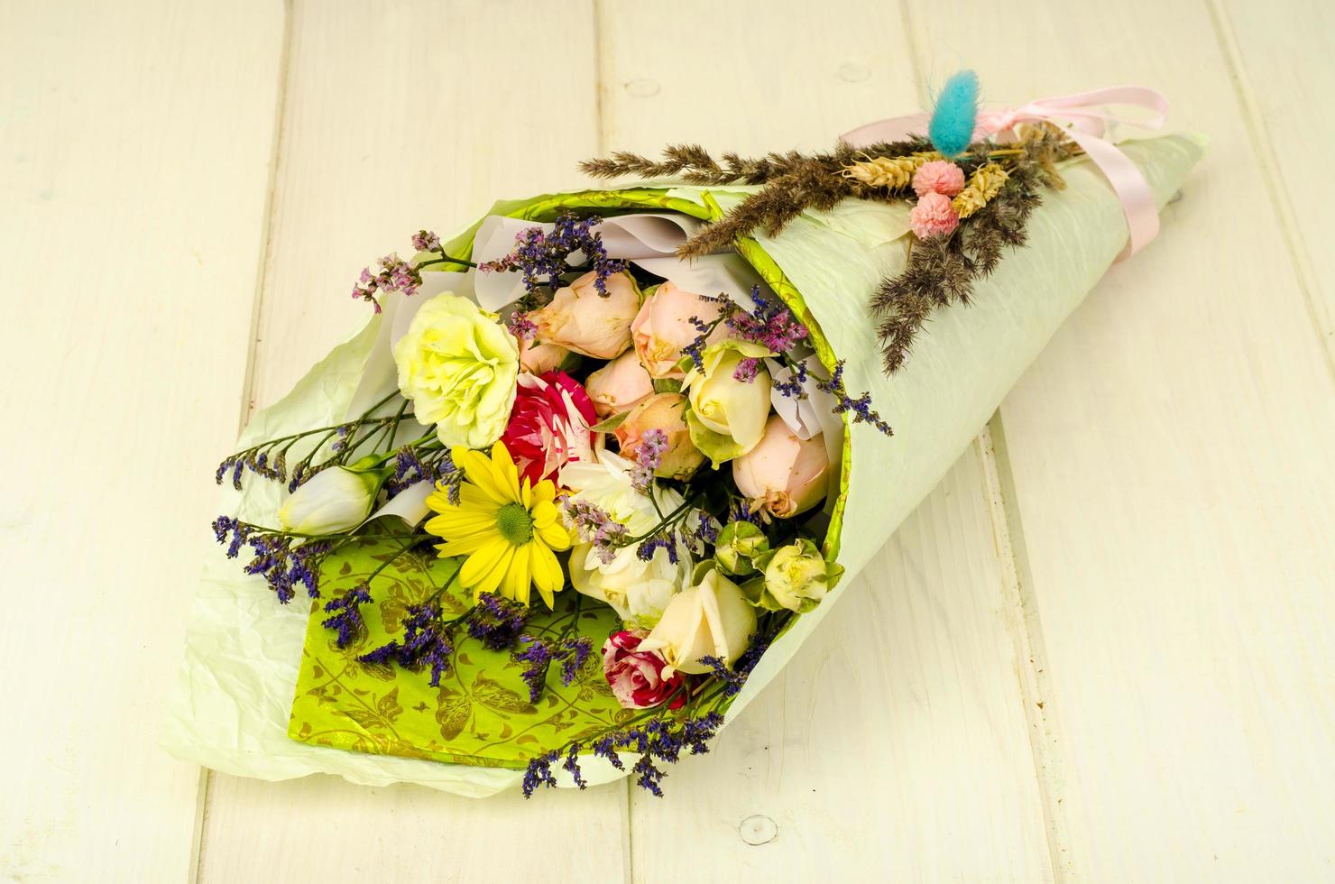 Ramo de flores envueltas en papel sobre mesa de madera blanca 4518881 Foto  de stock en Vecteezy