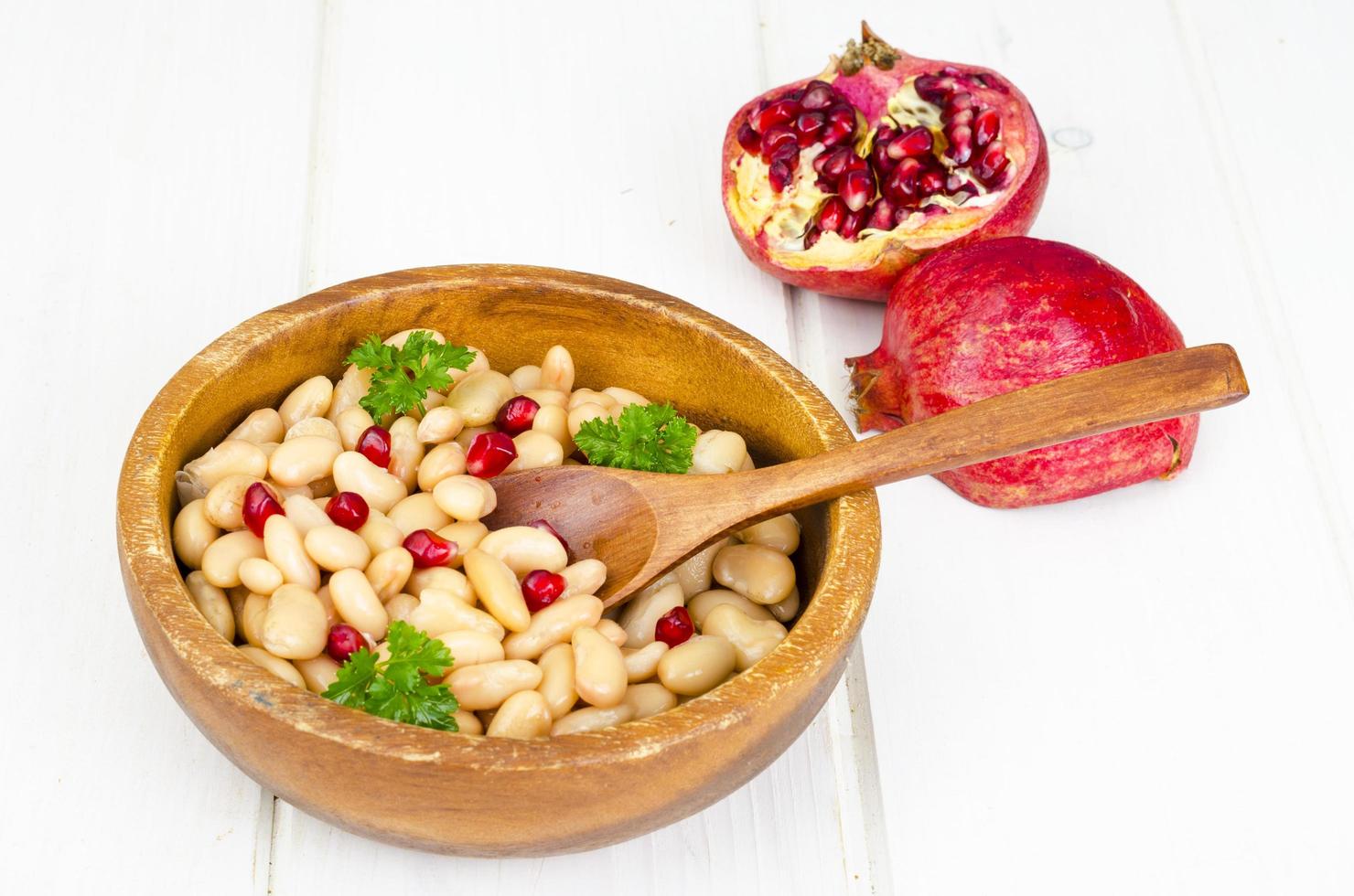 Dish with white beans and pomegranate seeds. photo