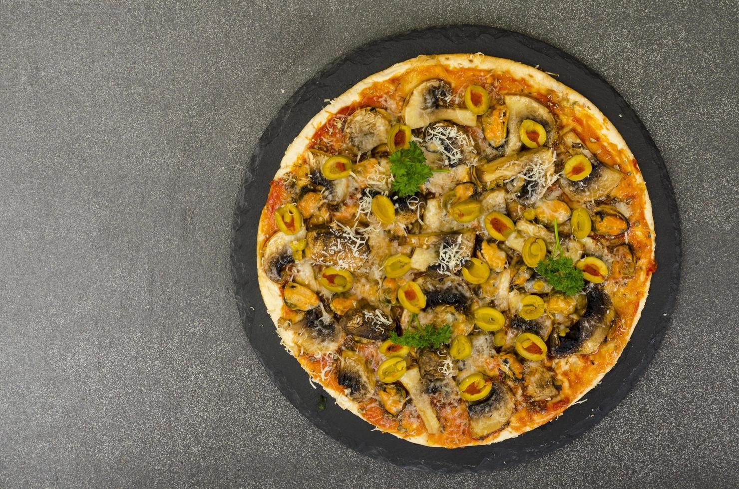 pizza con mejillones, champiñones, aceitunas verdes. foto de estudio