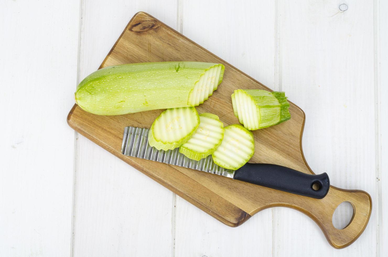 Green young fresh zucchini on wooden table for cooking photo