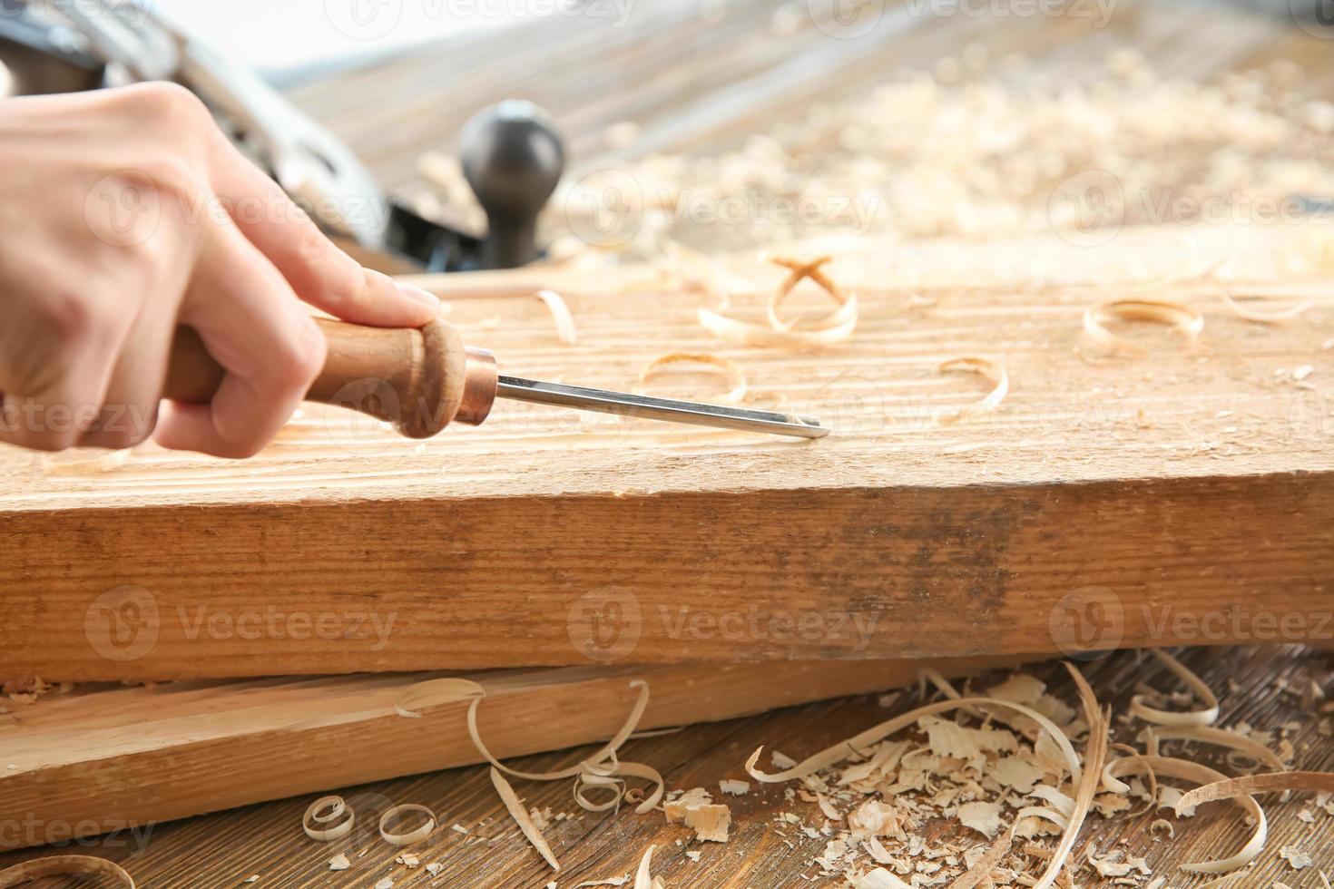 Carpenter working with chisel, closeup photo