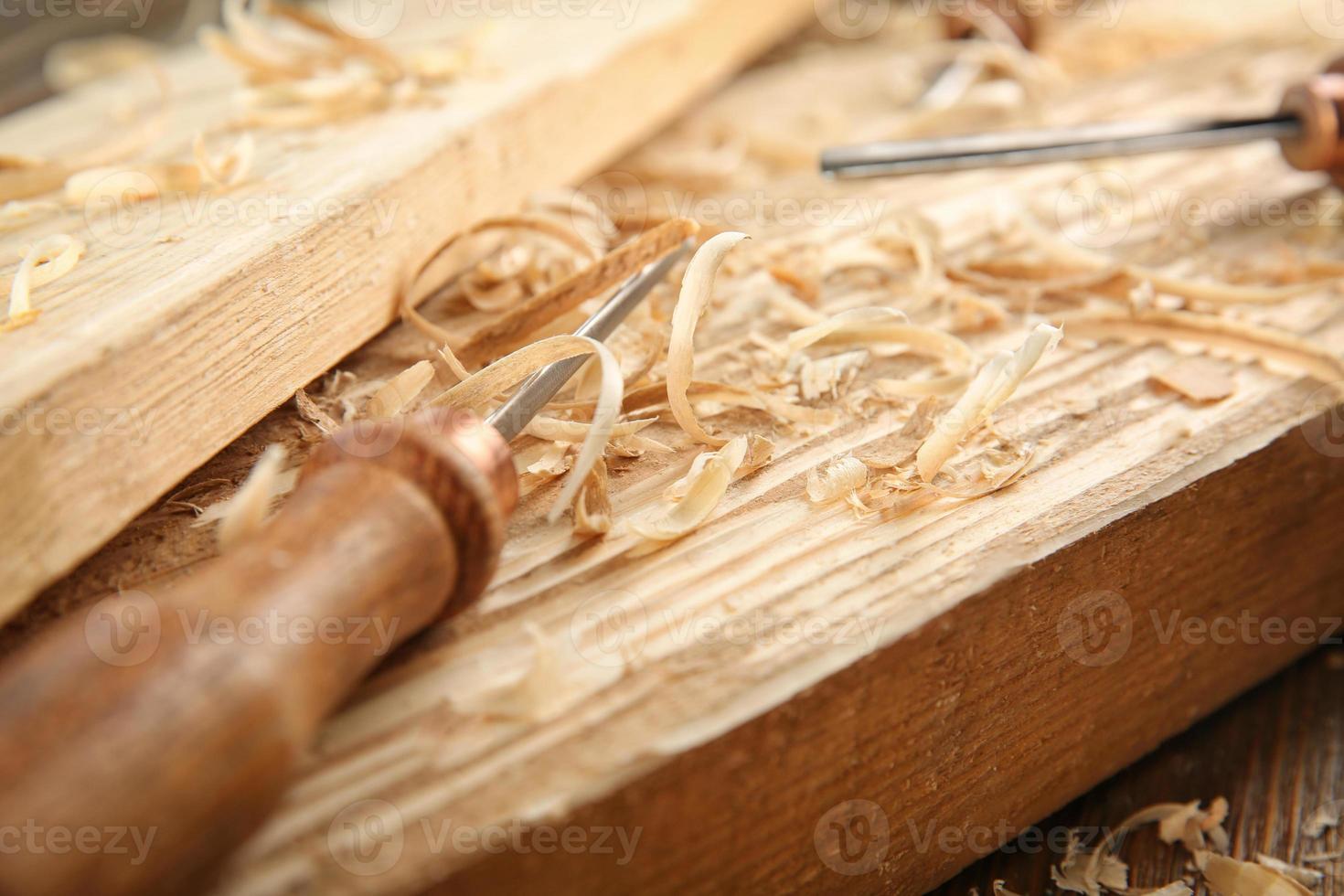 Cincel, tablas de madera y aserrín en el taller de carpintería foto