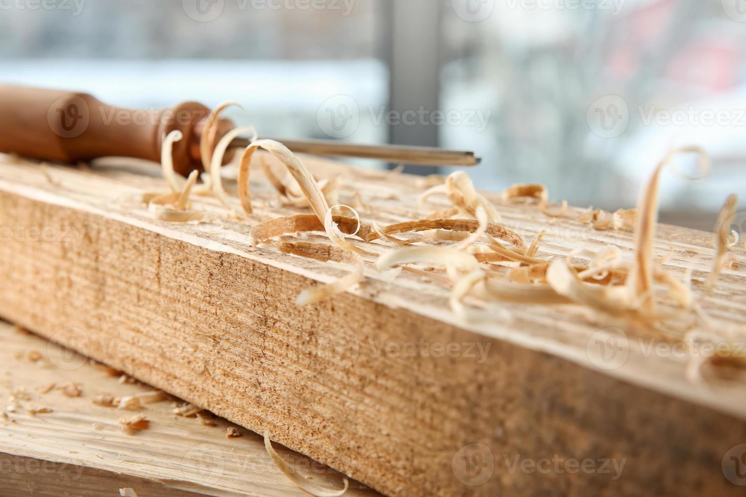 Chisel, wooden boards and sawdust in carpenter's workshop photo