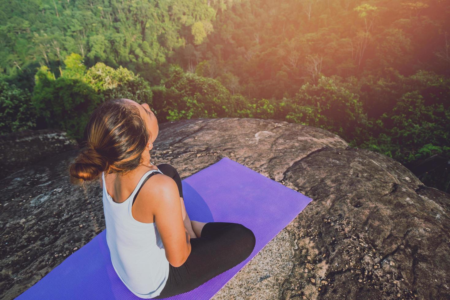 las mujeres asiáticas se relajan en las vacaciones. jugar si yoga. en el acantilado de roca de montaña. naturaleza de los bosques de montaña en tailandia foto