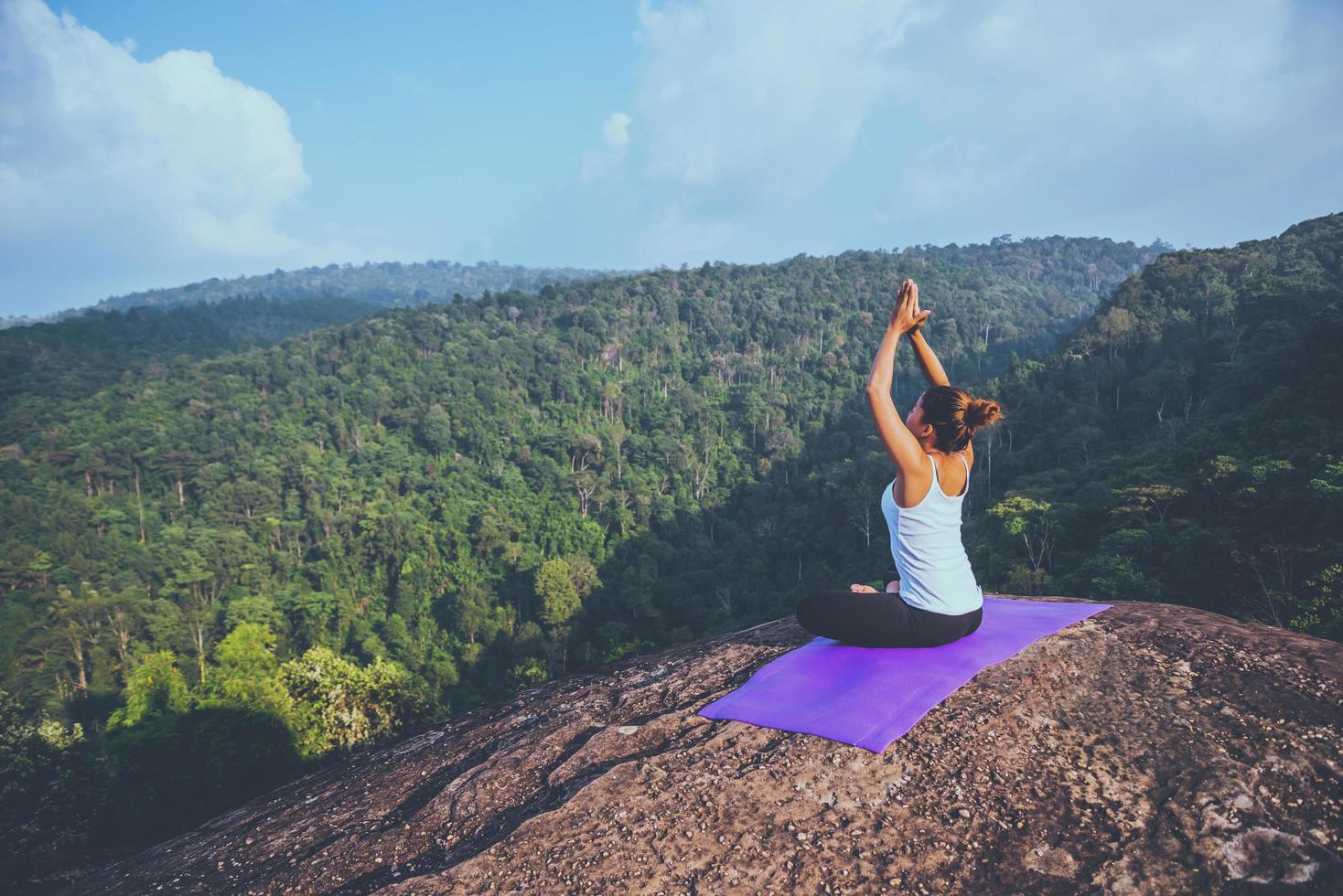 Asian women relax in the holiday. Play if yoga. On the Moutain rock cliff. Nature of mountain forests in Thailand photo