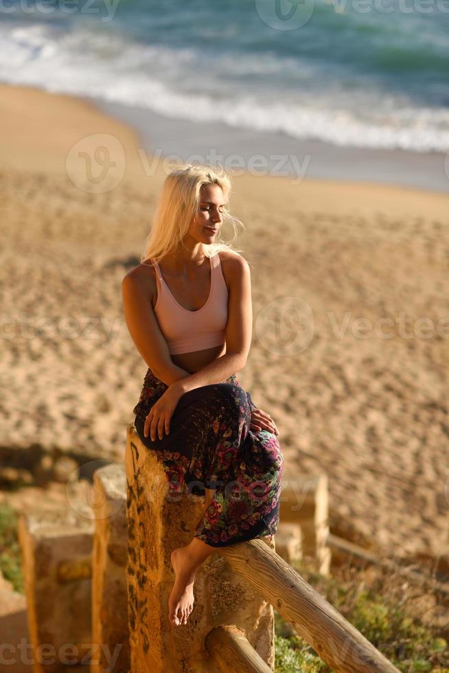 mujer disfrutando de la puesta de sol en una hermosa playa foto