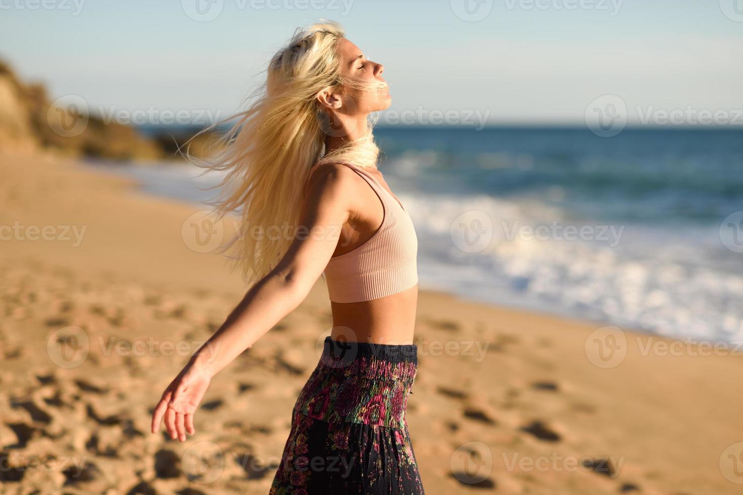 Woman enjoying the sunset on a beautiful beach photo