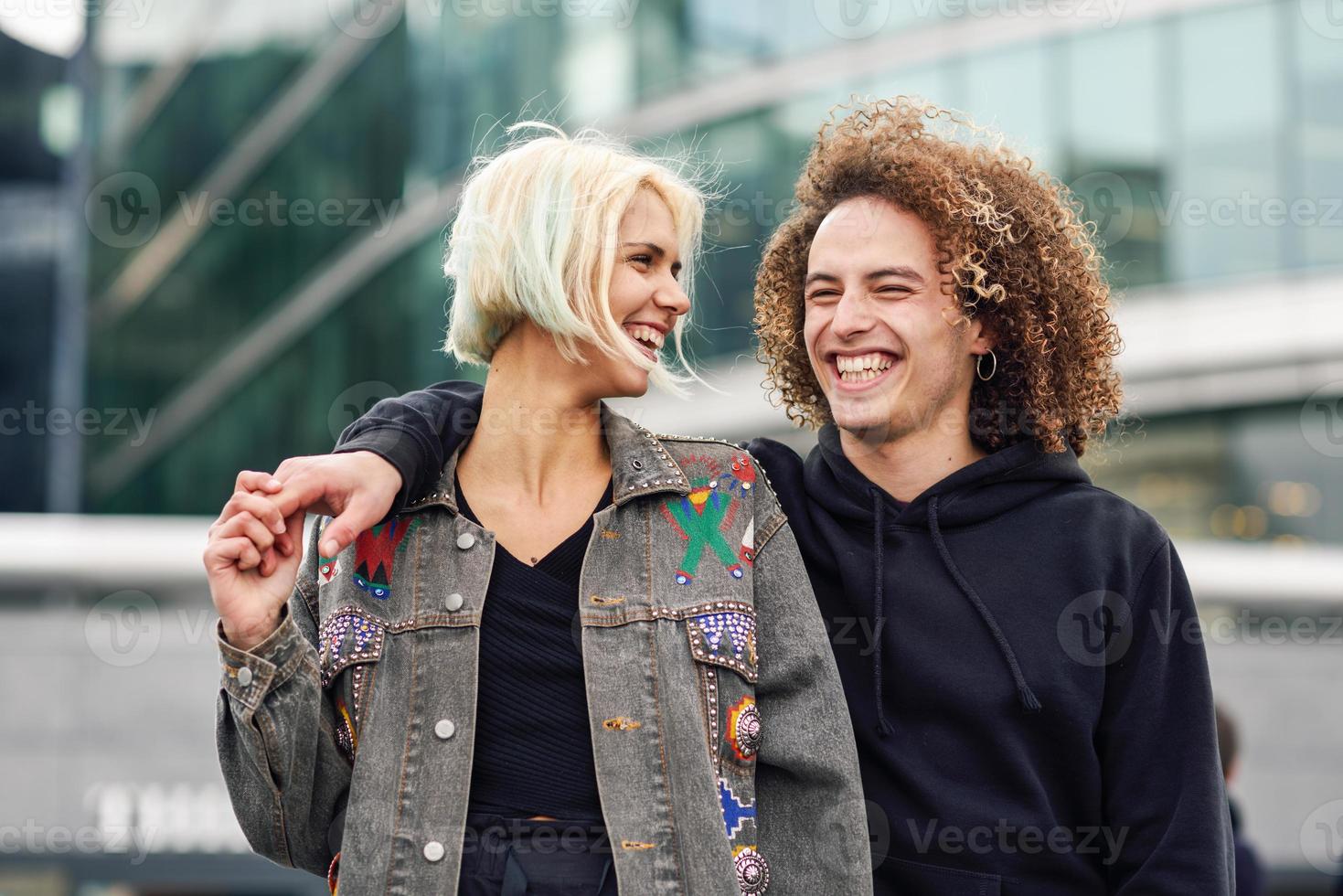 Happy young couple laughing in urban background photo