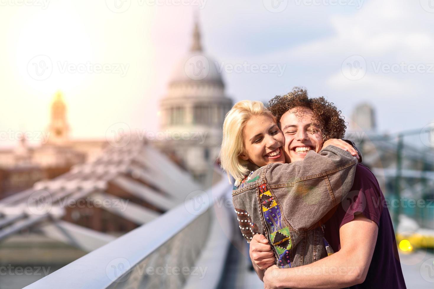 feliz pareja abrazándose por el puente del milenio, el río támesis, londres. foto