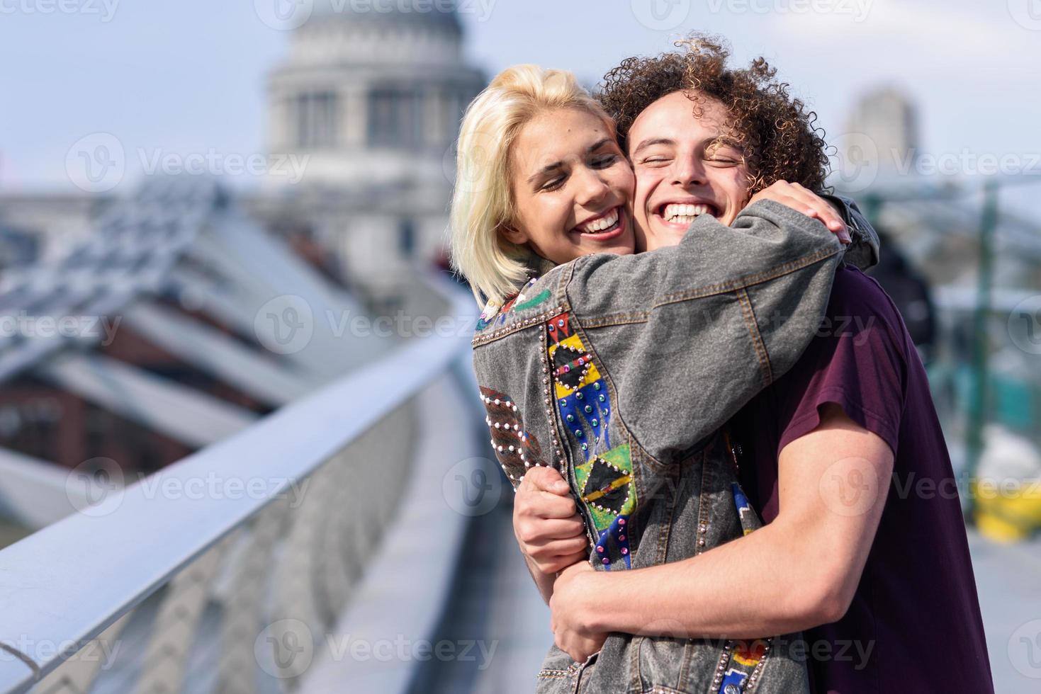 feliz pareja abrazándose por el puente del milenio, el río támesis, londres. foto