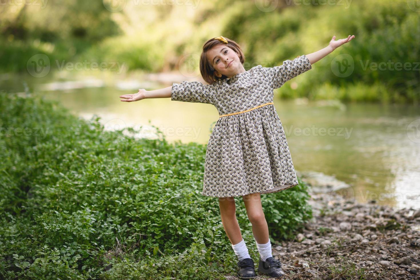 niña en el arroyo de la naturaleza con un hermoso vestido foto