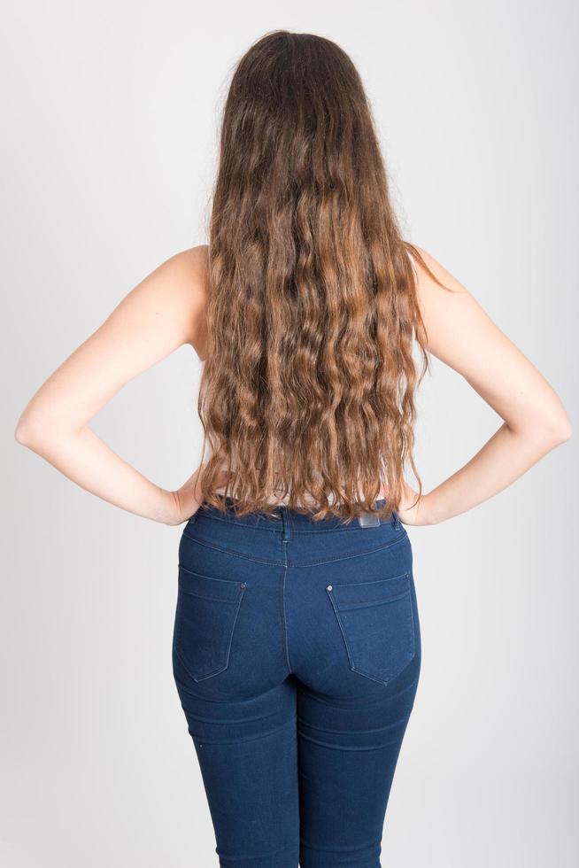 Mujer con cabello largo vistiendo camiseta blanca y jeans azules foto