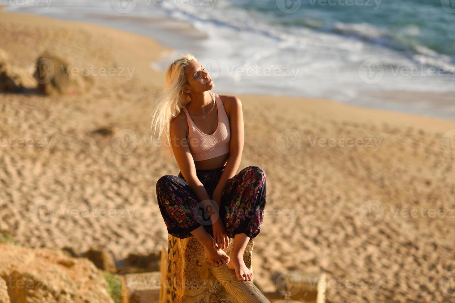 mujer disfrutando de la puesta de sol en una hermosa playa foto