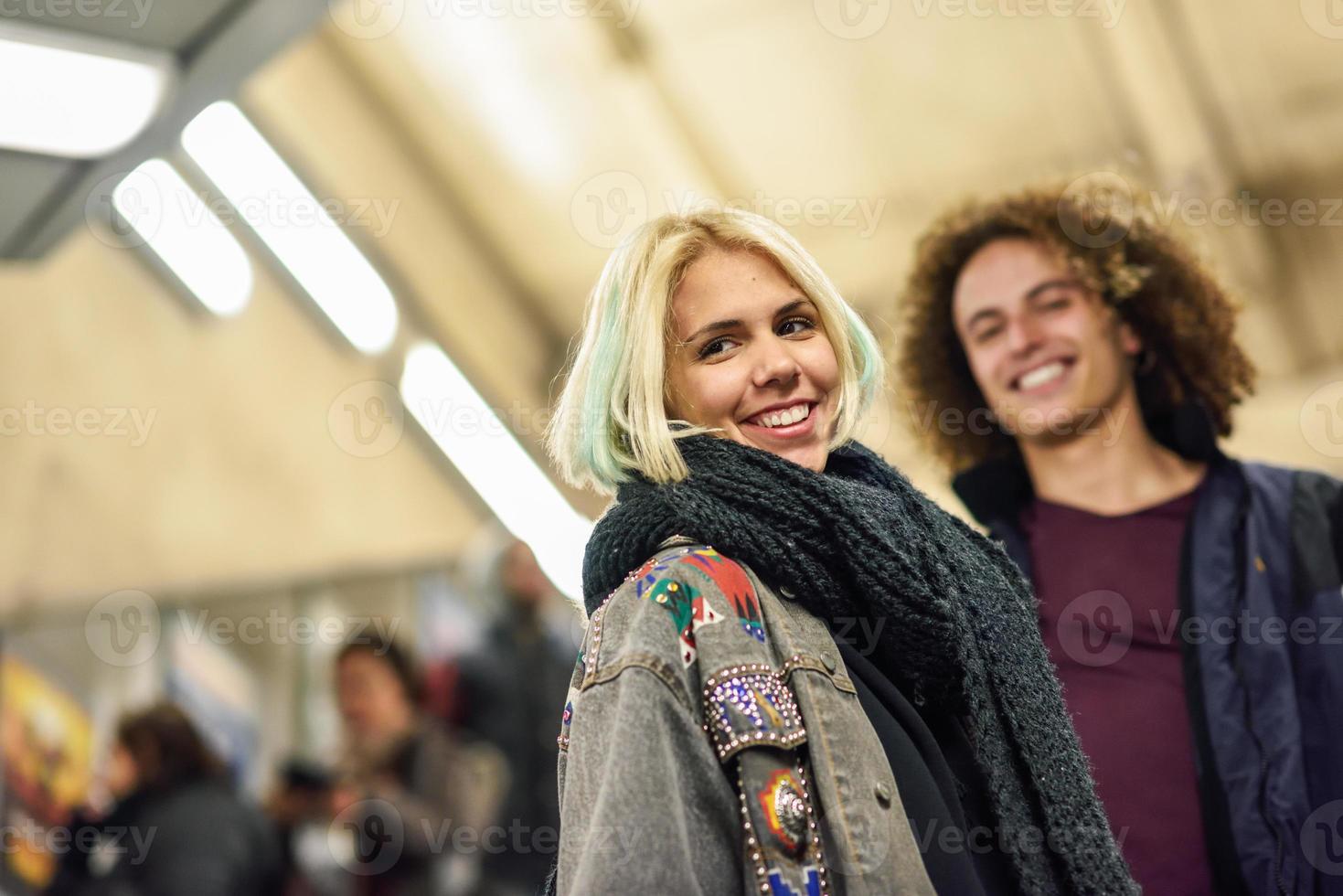 pareja joven subiendo las escaleras en una estación de metro. foto