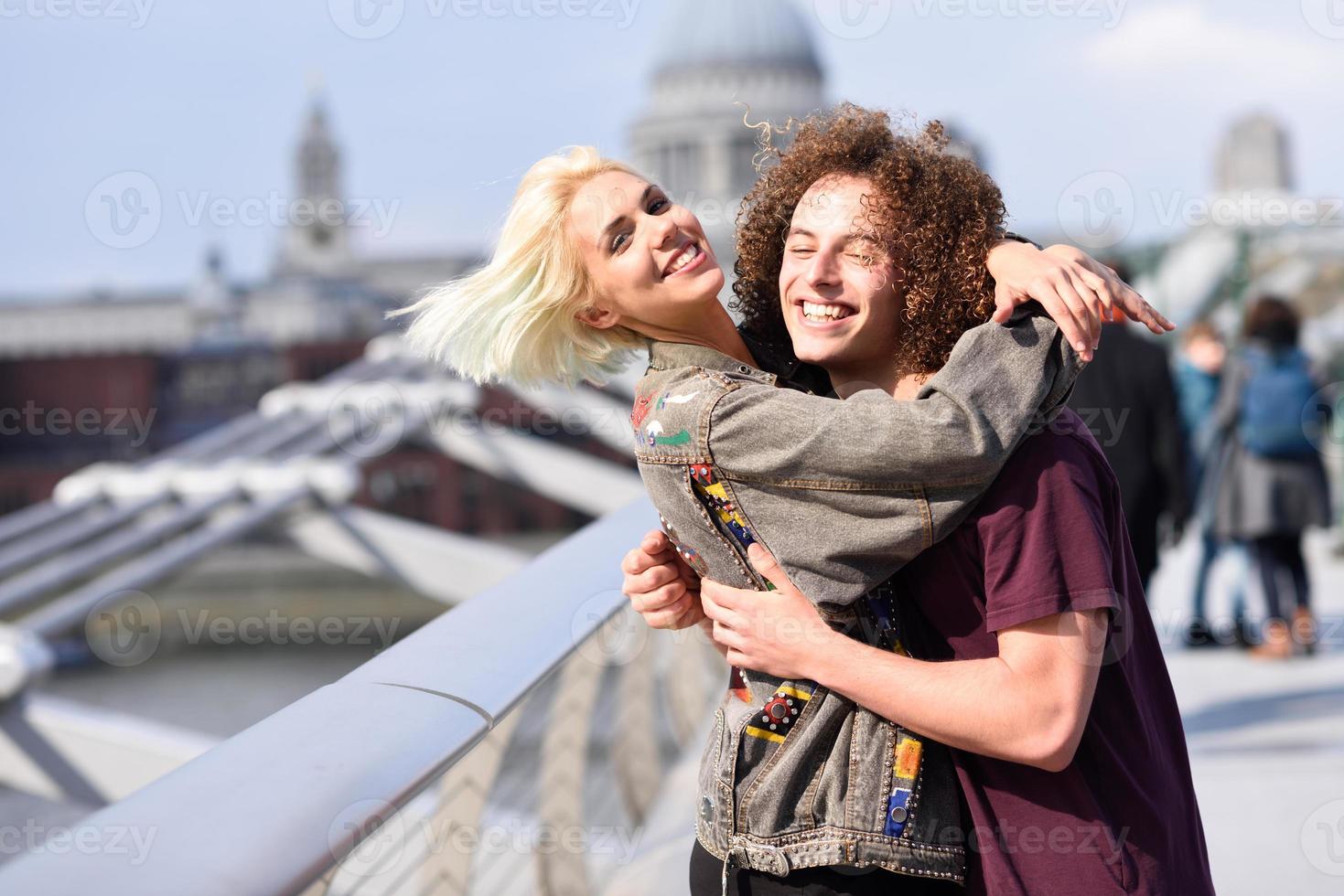 feliz pareja abrazándose por el puente del milenio, el río támesis, londres. foto