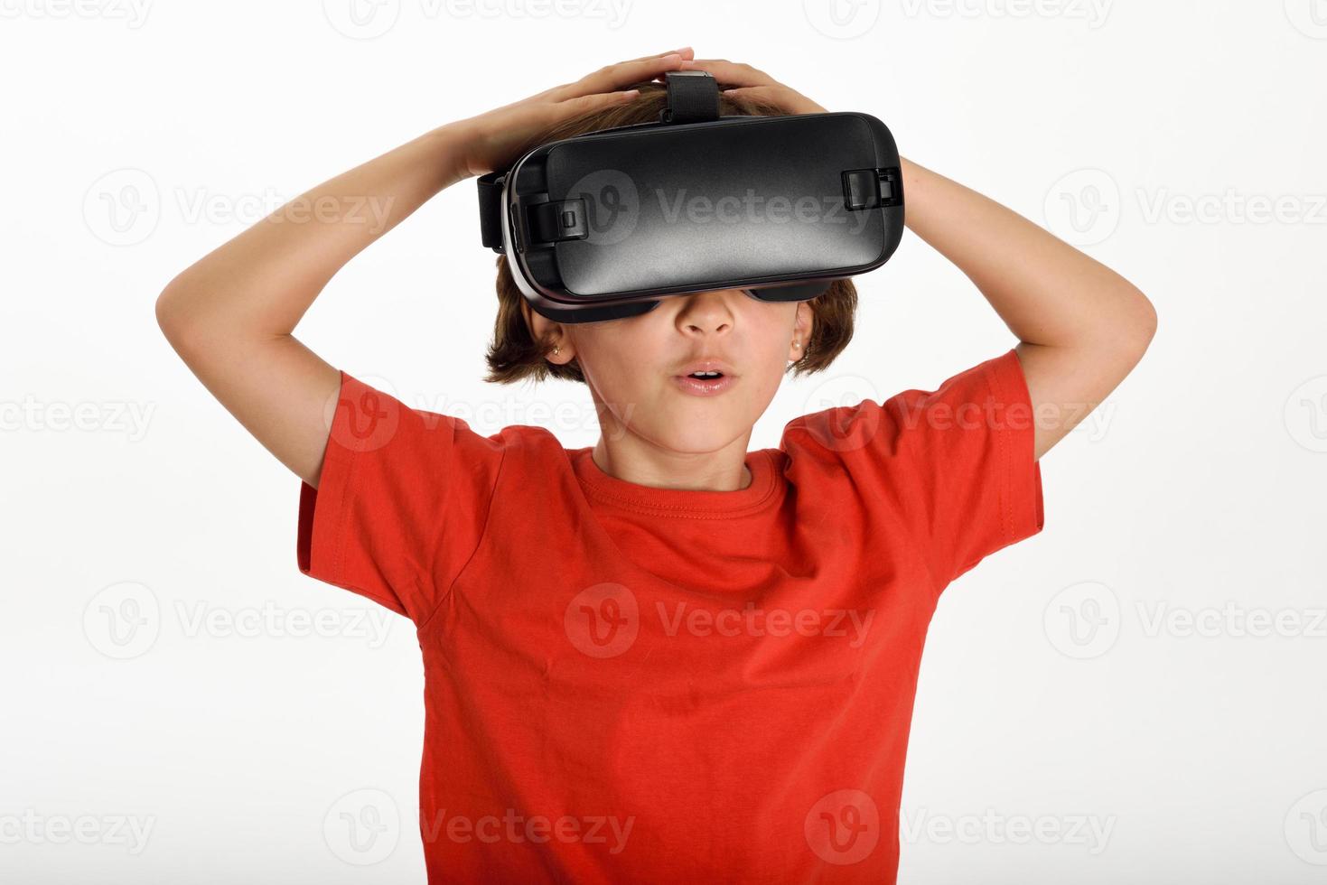 niña mirando con gafas de realidad virtual y gesticulando con las manos. foto